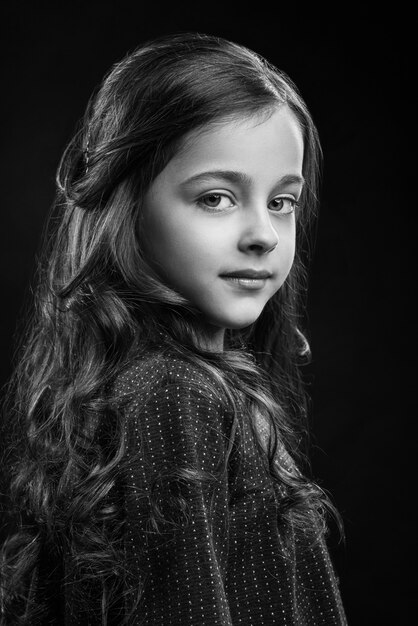 Retrato de niña encantadora en vestido posando en studio