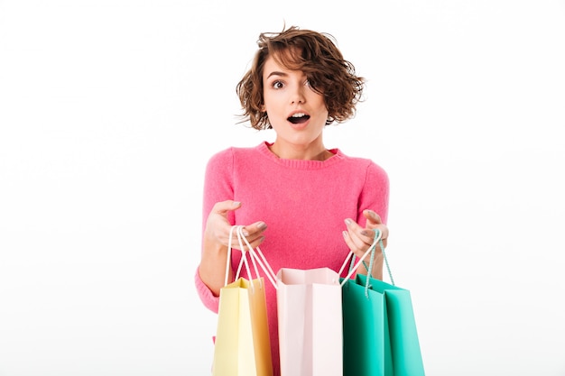 Retrato de una niña feliz emocionada abre bolsas de la compra