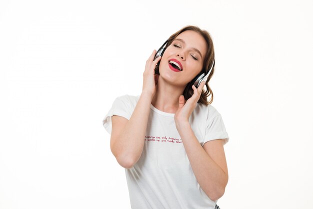 Retrato de una niña feliz escuchando música con auriculares