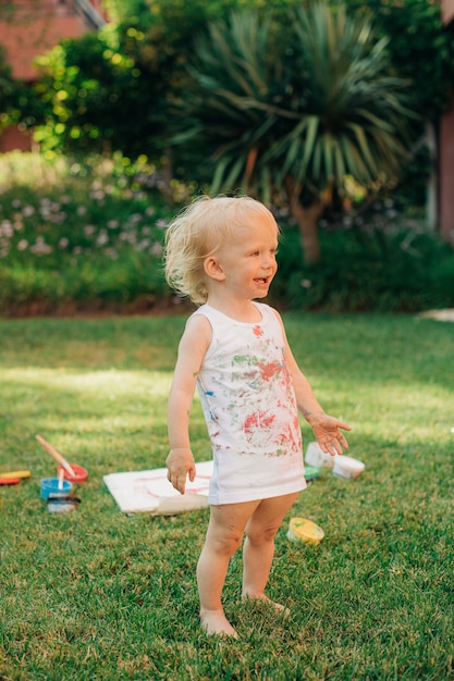 Retrato de niña feliz de pie en el patio delantero