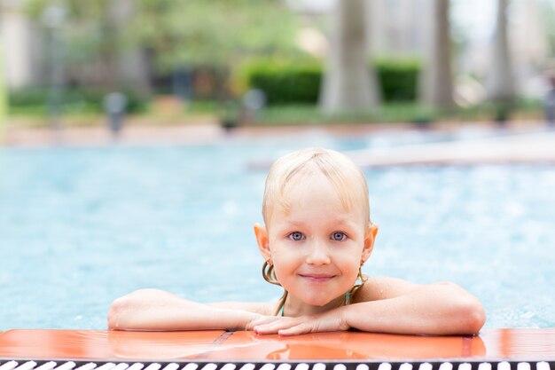 Retrato de niña feliz en la piscina