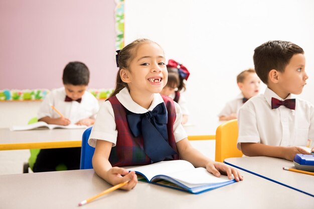 Retrato de una niña feliz a la que le faltan dientes asistiendo al preescolar y pasándola bien