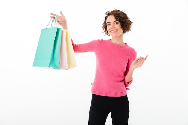 Foto gratuita retrato de una niña feliz satisfecha mostrando bolsas de compras