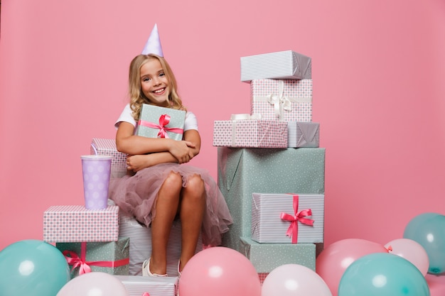 Retrato de una niña feliz en un sombrero de cumpleaños