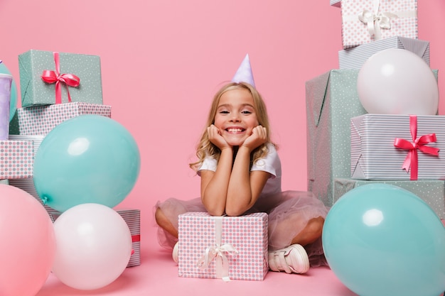 Retrato de una niña feliz en un sombrero de cumpleaños