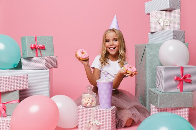 Retrato de una niña feliz en un sombrero de cumpleaños