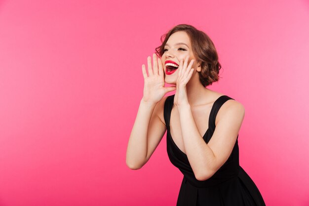 Retrato de una niña feliz vestida con vestido negro gritando