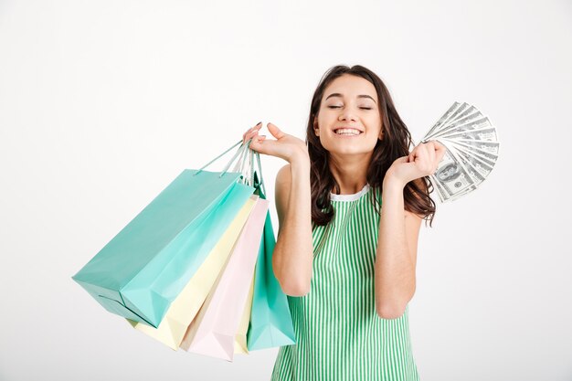 Retrato de una niña feliz en vestido con bolsas de compras