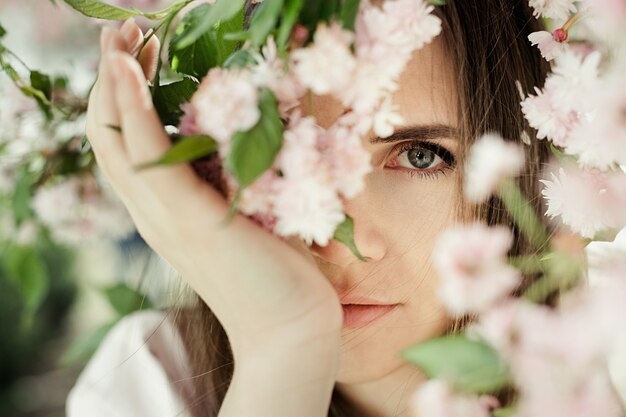 Retrato de niña entre flores de sakura de cerca