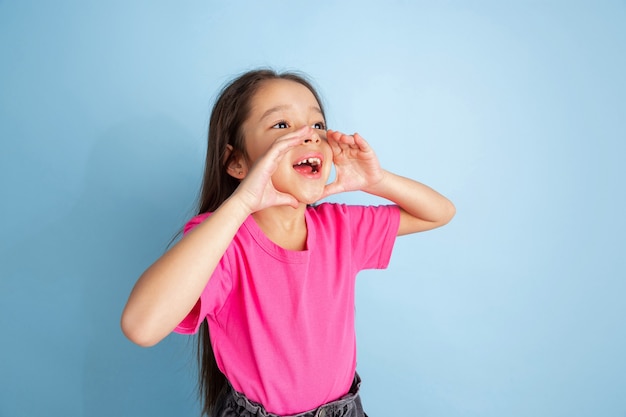 Foto gratuita retrato de niña gritando aislado en la pared azul del estudio