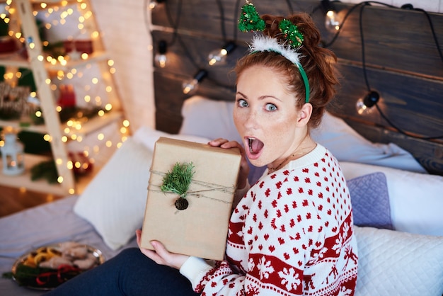 Retrato de niña gritando con regalo de Navidad