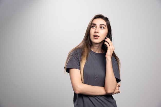 Retrato de una niña hablando por teléfono móvil y mirando a otro lado.