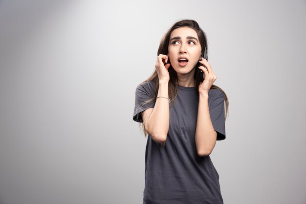 Retrato de una niña hablando por teléfono móvil y mirando a otro lado.