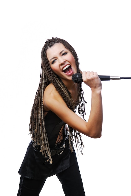 Retrato de niña hermosa cantante cantando con el micrófono en las manos