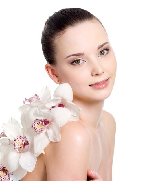 Retrato de niña hermosa con la piel limpia y con flores - fondo blanco.