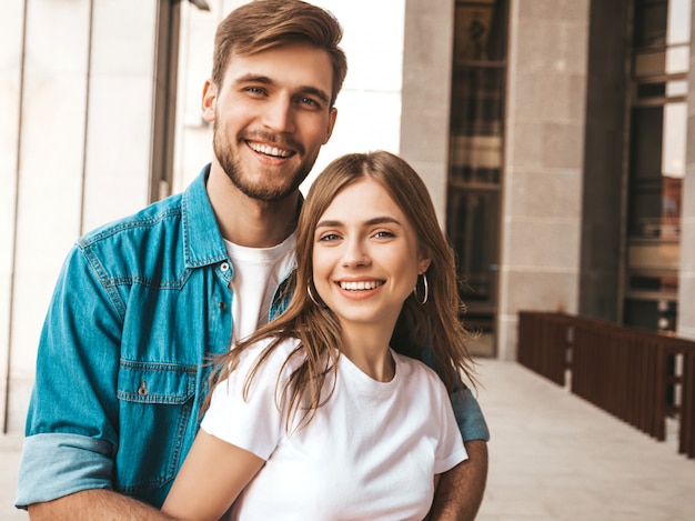 Foto gratuita retrato de niña hermosa sonriente y su novio guapo. mujer en ropa casual jeans de verano. . abrazando