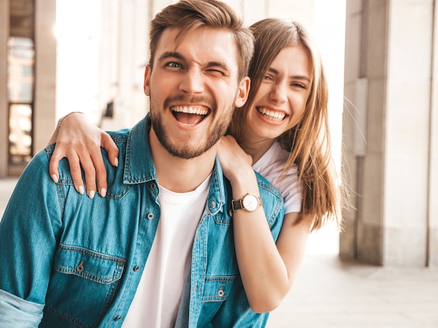 Retrato de niña hermosa sonriente y su novio guapo. Mujer en ropa casual jeans de verano. . Parpadeo