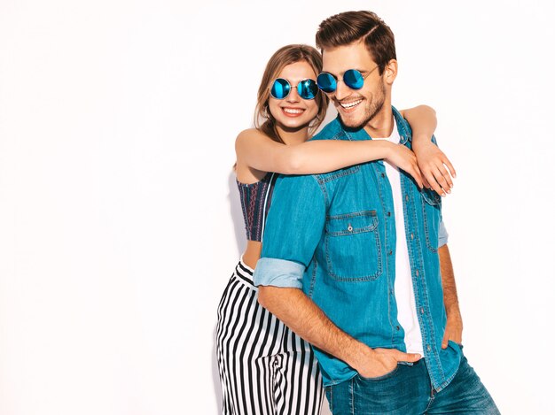 Retrato de niña hermosa sonriente y su novio guapo riendo. Feliz pareja alegre en gafas de sol.