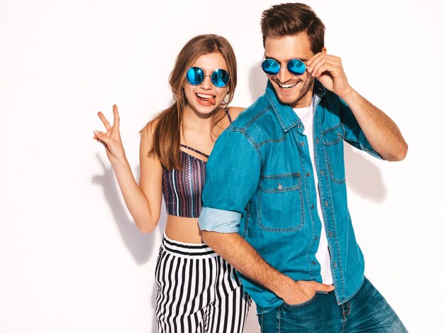 Retrato de niña hermosa sonriente y su novio guapo riendo. Feliz pareja alegre en gafas de sol.