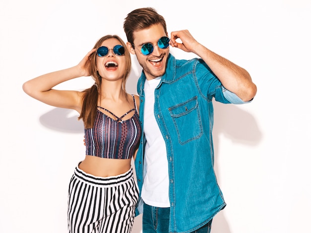 Retrato de niña hermosa sonriente y su novio guapo riendo. Feliz pareja alegre en gafas de sol.