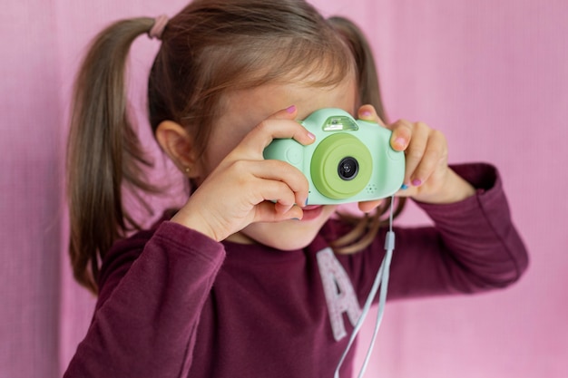 Foto gratuita retrato niña jugando con cámara