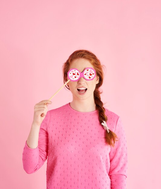 Retrato de niña juguetona celebrando el día de San Valentín en tiro de estudio