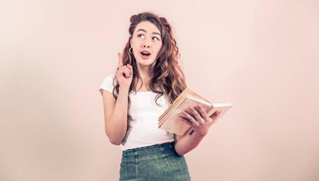 Retrato de una niña con un libro sobre un fondo de color