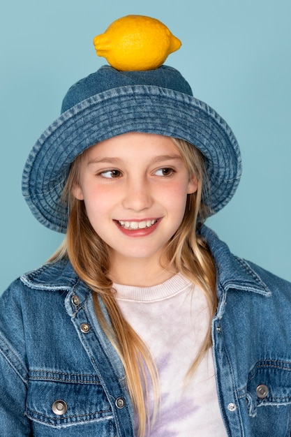 Retrato de niña con un limón en la cabeza