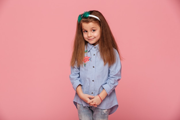 Retrato de niña linda con cabello castaño largo mirando con una sonrisa amable