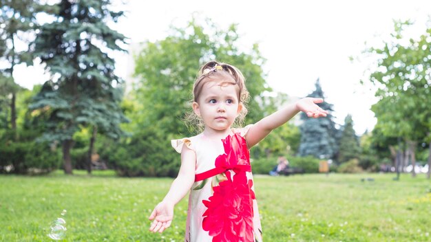 Retrato de niña linda de pie en el jardín