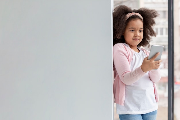 Retrato de niña linda con teléfono móvil