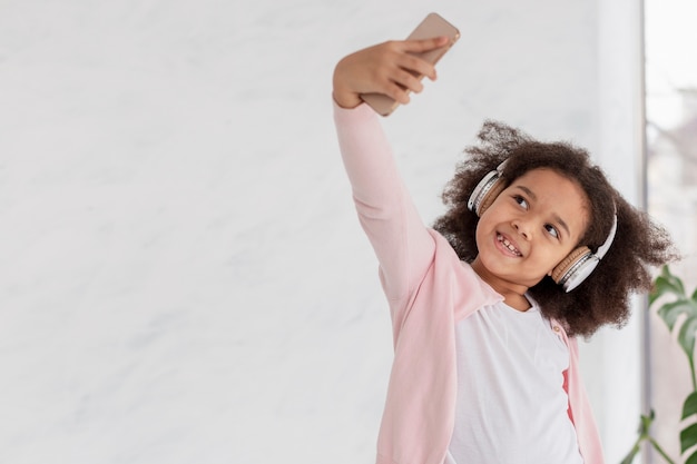 Retrato de niña linda tomando un selfie