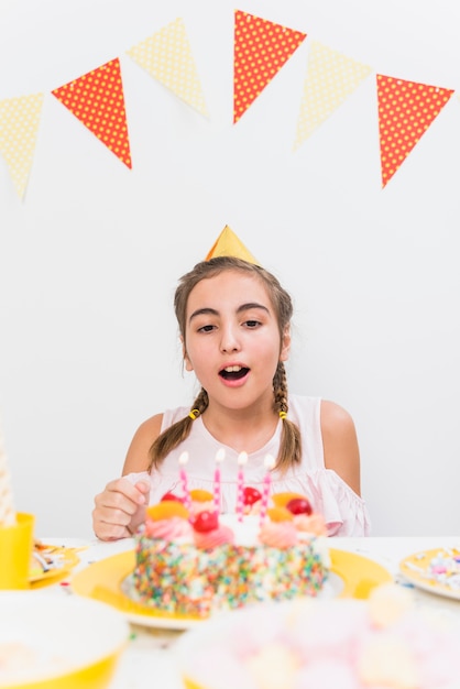 Retrato de una niña lista para soplar la vela de cumpleaños
