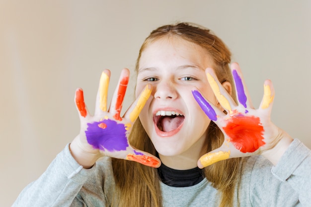 Retrato de una niña con las manos pintadas