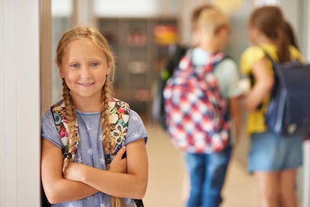 Foto gratuita retrato de niña con mochila en el pasillo de la escuela