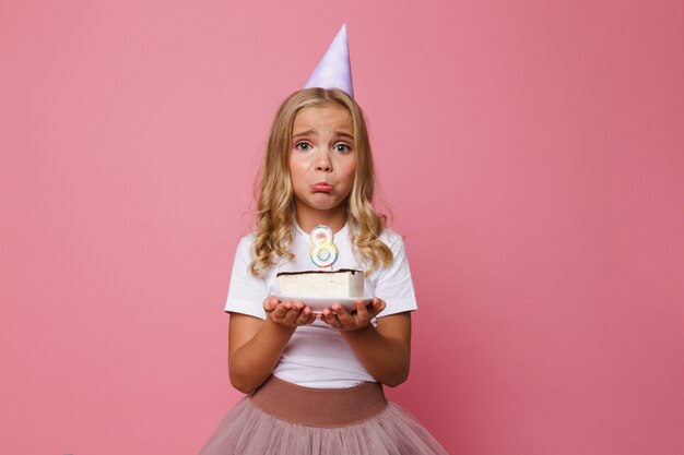 Retrato de una niña molesta en sombrero de cumpleaños