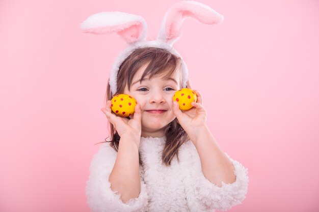 Retrato de una niña con orejas de conejo con huevos de Pascua