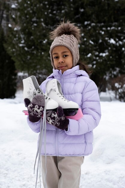 Retrato de niña con patines de hielo al aire libre en invierno