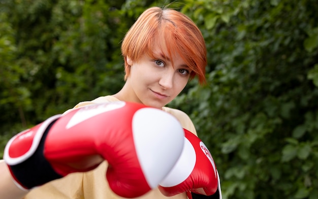 Foto gratuita retrato de niña pelirroja confiada con guantes de boxeo