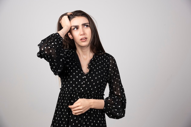 Retrato de niña pensativa cogidos de la mano en la cabeza.