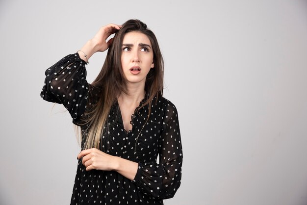 Retrato de niña pensativa cogidos de la mano en la cabeza.