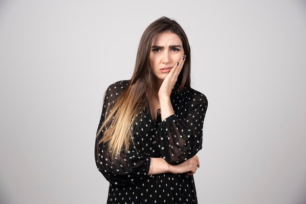 Retrato de niña pensativa cogidos de la mano en la cabeza.