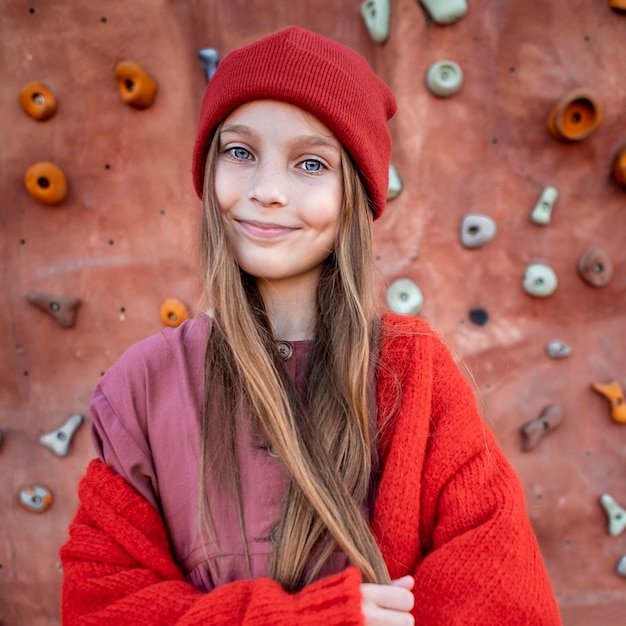 Retrato de niña de pie junto a paredes de escalada