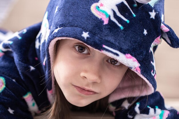 Retrato de una niña en pijama con capucha