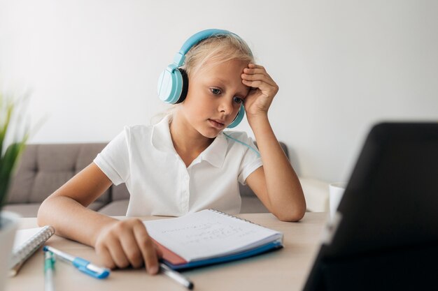 Retrato de una niña prestando atención a la clase en línea