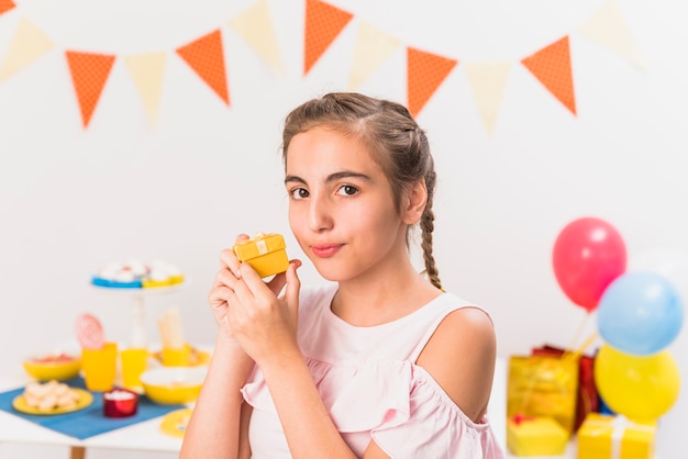 Foto gratuita retrato de una niña con regalo durante la fiesta de cumpleaños