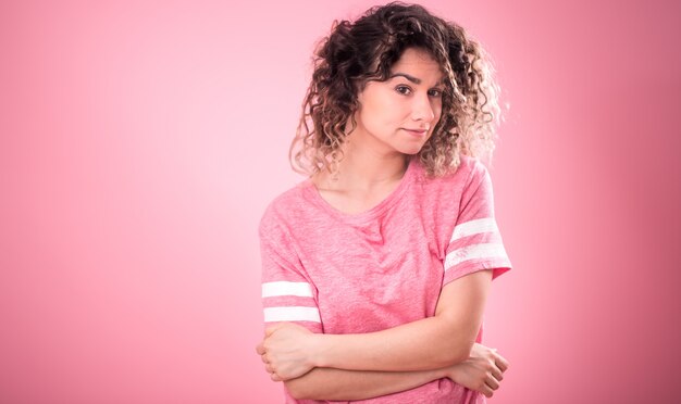 Retrato de niña rizada sobre fondo rosa aislado