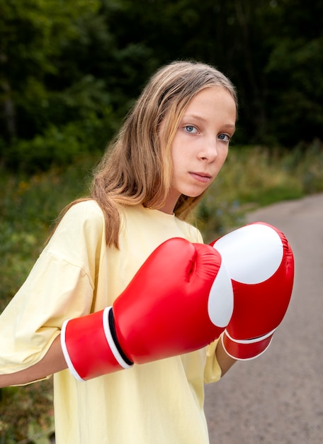 Retrato de niña segura con guantes de boxeo