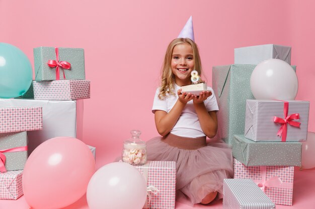 Retrato de una niña en un sombrero de cumpleaños celebrando