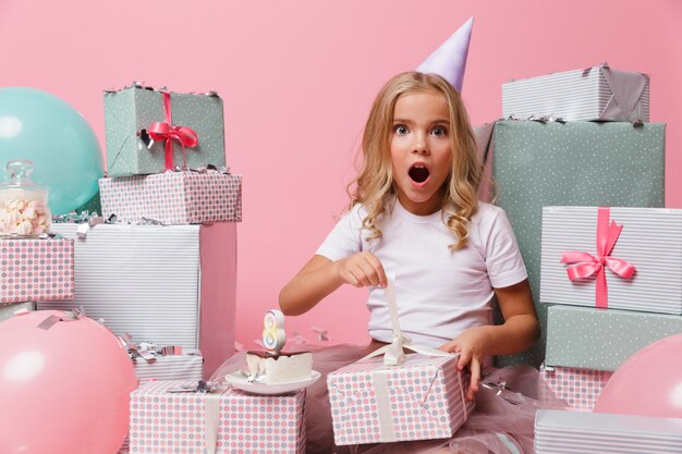 Retrato de una niña en un sombrero de cumpleaños celebrando